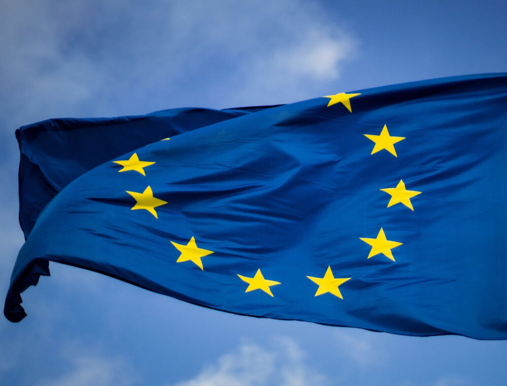 The Flag of the EU in the wind. In the Background you can see the blue sky.