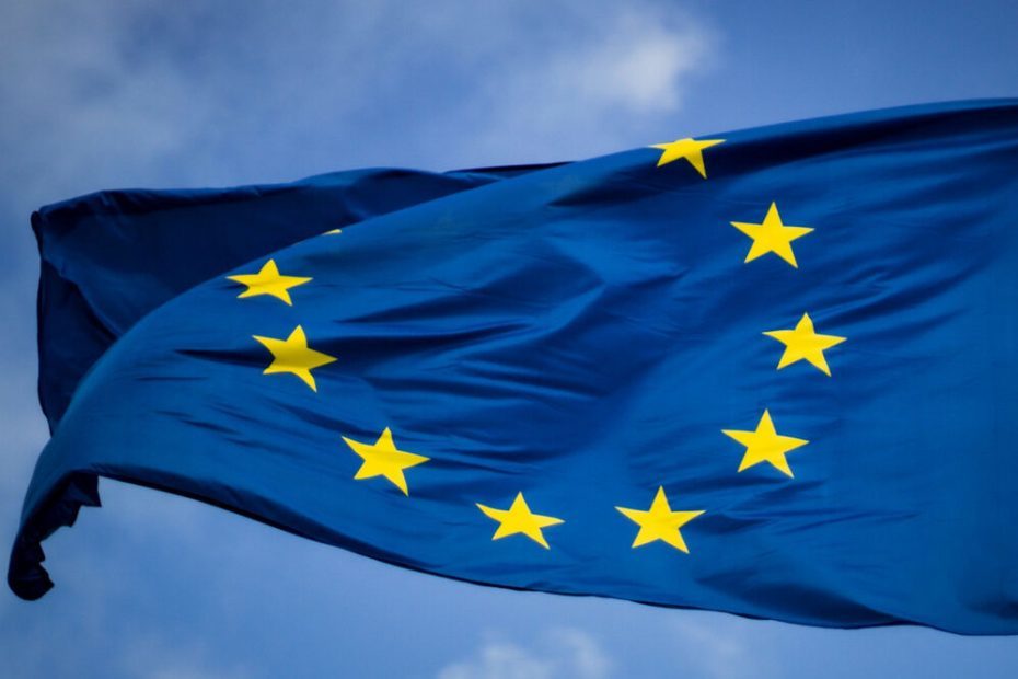 The Flag of the EU in the wind. In the Background you can see the blue sky.